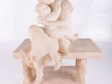 statue of a woman sitting on a bench holding a baby