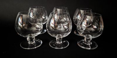 trois verres à vin vides sont alignés sur une surface noire