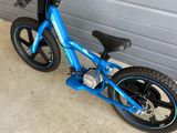 un vélo bleu garé devant la porte d'un garage