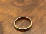 a close up of a gold ring on a wooden surface