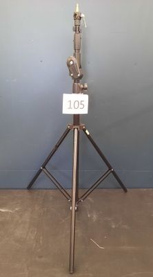 a tripod with a sign on it in front of a blue wall