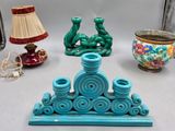 trois vases de couleurs différentes et une lampe posés sur une table