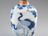 a blue and white vase with a bird on it