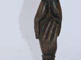une petite statue en bronze représentant une femme tenant un vase