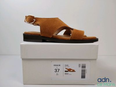 un gros plan sur une paire de sandales posée sur une boîte