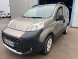 La petite camionnette est garée devant un immeuble.
