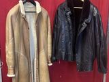 two coats hanging on a rack in front of a red wall