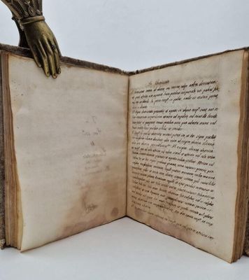 an open book with a hand holding a bookmark on top of it