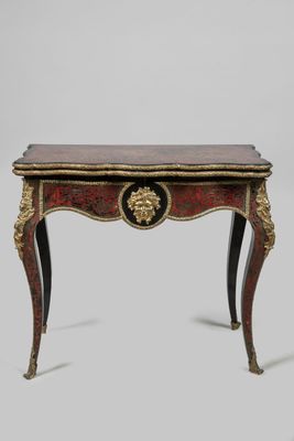 une petite table dont le plateau est orné de motifs dorés et rouges