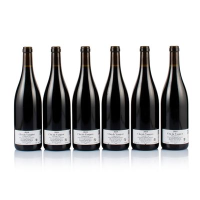 six bottles of wine lined up in a row on a white surface