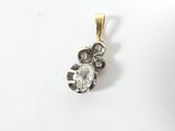 une photo d'un pendentif en diamant posé sur une surface blanche