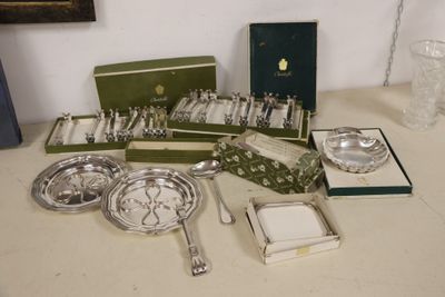 a lot of silverware on a table next to a glass