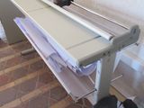a white ironing board on a stand next to a black bag