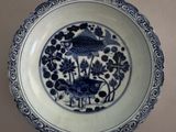 a blue and white plate with flowers and birds on it