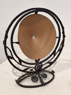 un objet métallique surmonté d'un disque en bois