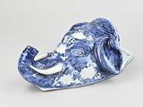 a blue and white elephant figurine sitting on a white surface