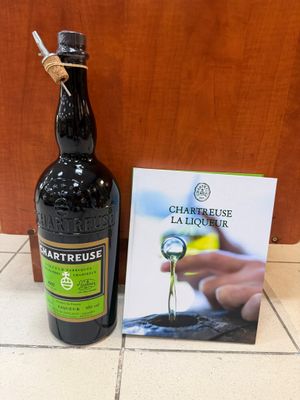 une bouteille d'alcool posée à côté d'un livre, par terre