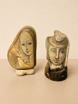 two stone sculptures of a woman and a man on a table