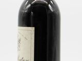 an old bottle of wine with a red cap on a white background