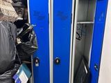 a blue locker in a room with a lot of trash