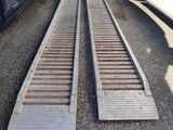 two wooden ramps on the ground next to a car
