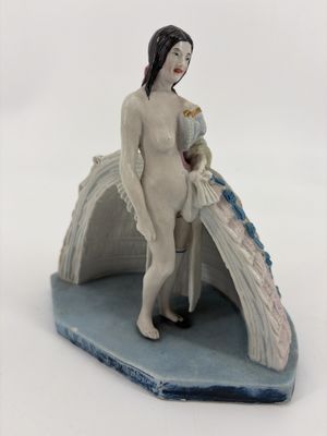 a figurine of a woman standing on a rock