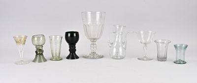de nombreux vases en verre de différentes formes sur une surface blanche