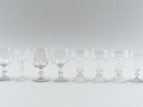 seven wine glasses and a decanter on the table