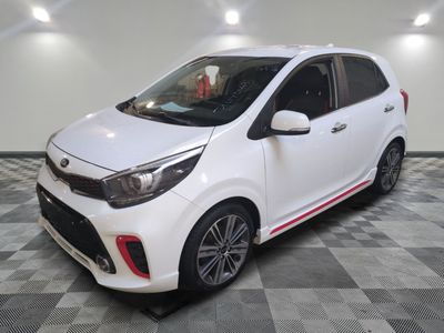 une voiture blanche garée sur un sol en damier dans un garage