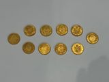 a close up of a group of gold coins on a white surface