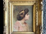 an old picture of a woman in a pink dress in a gold frame on a blue carpet