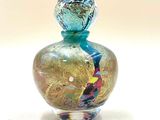 une petite bouteille en verre ornée d'un motif coloré
