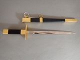 pair of two black and gold swords on a gray surface