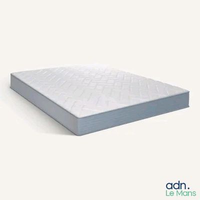une photo d'un matelas posé sur une surface blanche