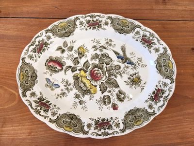 a plate with a bird design on it on a wooden table