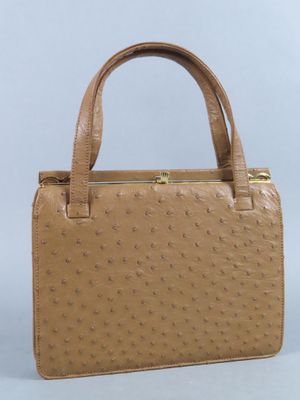un sac à main en cuir d'autruche beige avec des finitions dorées