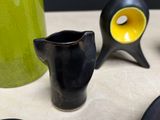 a black vase and a yellow vase on a table
