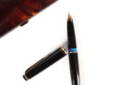un stylo posé sur une table à côté d'un autre stylo