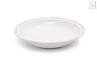 un bol blanc orné d'une bordure bleue, posé sur une surface blanche