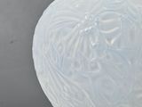 a white vase sitting on a table with a gray background