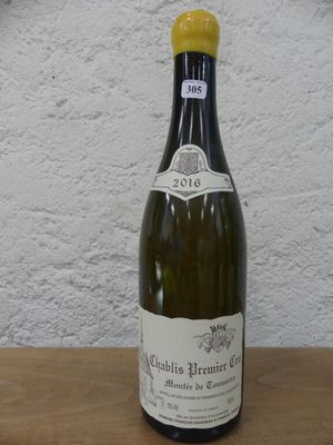 une bouteille de vin posée sur une table, avec une horloge en arrière-plan