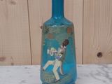 un vase en verre bleu sur lequel est représenté un garçon