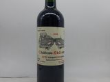 une bouteille de vin rouge posée sur une table blanche