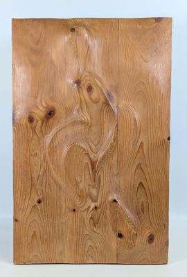 un gros plan sur un morceau de bois sur lequel est sculpté un oiseau