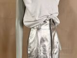 the mannequin is wearing a silver skirt and a white shirt