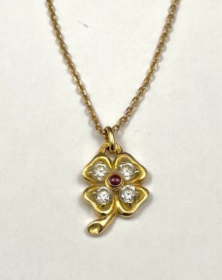 a gold necklace with a diamond flower pendant on a gold chain