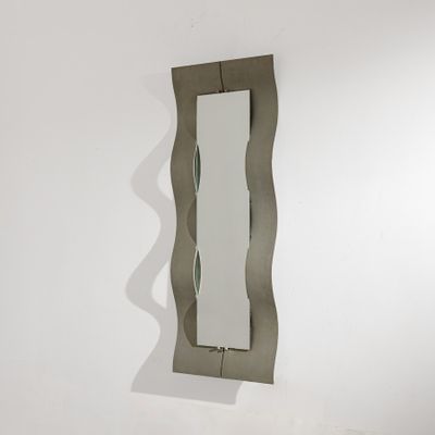 un miroir accroché au mur à côté d'un lavabo