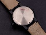 the watch is on a black surface with a brown leather strap
