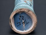 a close up of a blue vase with a picture on it