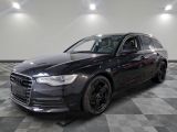 the black audi is parked in a clean room with a checkered floor